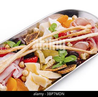 Speisen, Eine lebendige Auswahl an Vorspeisen mit Wurstwaren, Käse, getrockneten Früchten und Nüssen, die künstlerisch zubereitet werden. Frische Kräuter fügen Sie einen Spritzer Colour hinzu Stockfoto