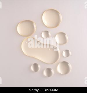 Ölserumtropfen. Flüssige Tropfen auf beigefarbenem Hintergrund. Kosmetisches Mittel mit Blasennaht Stockfoto