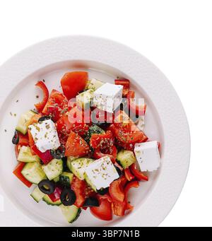 Essen, Blick von oben auf einen bunten griechischen Salat serviert auf einem weißen Teller, isoliert auf weißem Hintergrund Stockfoto