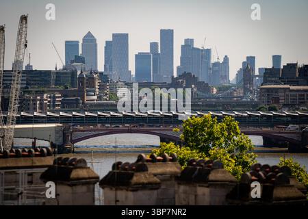 Dateifoto vom 08/22 von einem Blick auf die Blackfriars Bridge und Canary Wharf in London an einem sonnigen Tag. Finanzunternehmen erwarten in den kommenden Monaten eine Beschleunigung des Arbeitsplatzverlusts, wobei die Investitionspläne durch die Nachfragesorgen belastet werden und der Optimismus ein neues tief erreicht, wie eine neue Umfrage zeigt. Ausgabedatum: Montag, 7. Juli 2025. Stockfoto