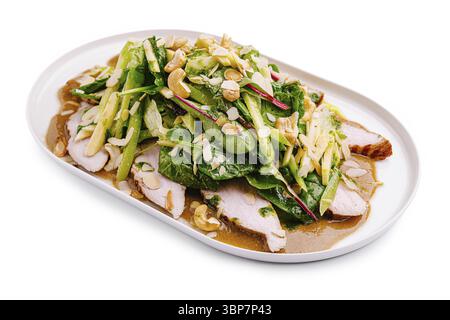 Ein lebhafter Salat besteht aus gegrillten Hähnchenscheiben auf einem Bett aus gemischtem Gemüse, garniert mit frischen Kräutern, Nüssen und einem herzhaften Dressing. Perfekt für Stockfoto