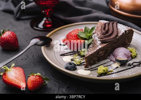 Essen, Brownie-Kuchen mit einer Schaufel Vanilleeis und Erdbeeren Stockfoto