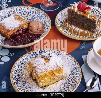Essen, verführerische Auswahl verschiedener Desserts, die elegant auf einem lebhaften Tisch serviert werden Stockfoto