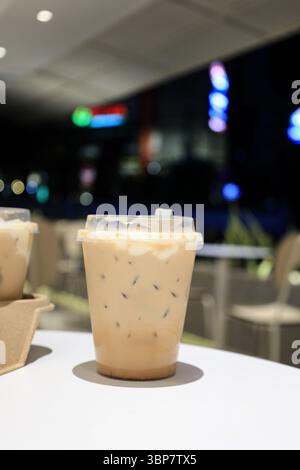 Eiswolkenkenkaffee in Plastikbecher in einem Coffee Shop, Espresso mit Eiswürfeln und cremigem Milchschaum auf Top Like Cloud Stockfoto