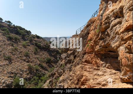 Wanderer navigieren durch felsiges Gelände in der Nähe der Milatos-Höhle und genießen die atemberaubende kretische Landschaft. Stockfoto