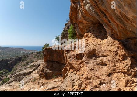 Besucher wandern in der Nähe der Milatos-Höhle und genießen die malerische Aussicht auf die Küste und die Landschaft. Stockfoto