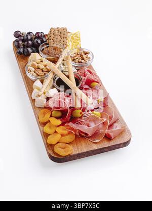 Essen, Eine wunderschön gestaltete Wurstplatte zeigt Wurstwaren, verschiedene Käsesorten, Obst und Nüsse. Diese reizvolle Auswahl ist perfekt für Unternehmungen Stockfoto