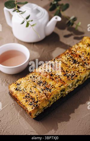 Essen, frisch gebackener Brotbrot mit Sesamsamen bestreut, serviert mit heißem Tee Stockfoto