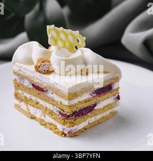 Essen, Nahaufnahme eines geschichteten Kuchens mit Sahnezuckerung, serviert mit Kaffee Stockfoto