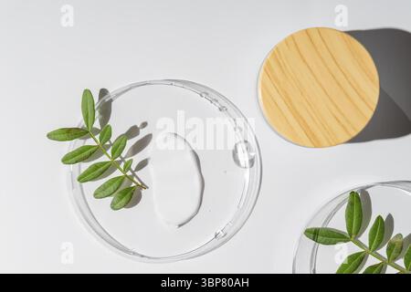 Gesichtscreme in einem Glas und Feuchtigkeitsspender in Petrischale auf weißem Hintergrund. Schönheit Gesichtspflege Textur von oben. Körperpflegelotion Stockfoto