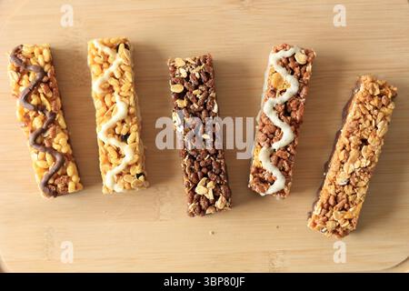 Verschiedene gesunde Müsli Granola Energy Bar auf hölzernem Hintergrund, Top View Stockfoto