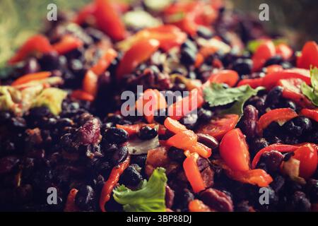 Zeigt flache Nahaufnahme von Bohnensalat mit Bohnen, Paprika, Tomaten, verschwommenem Hintergrund Stockfoto