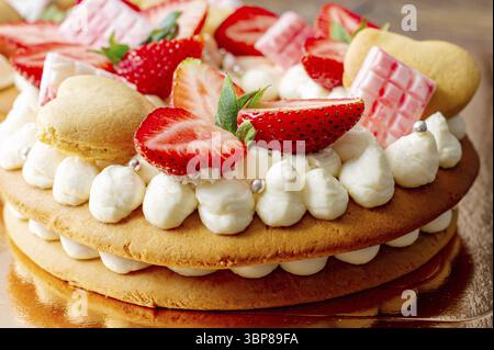 Biskuitkuchen mit Erdbeeren, rosa Milchschokolade, Silberstreuseln, Vanillecreme und herzkranken Keksen aus nächster Nähe. Sommer süßes Dessert für bi Stockfoto