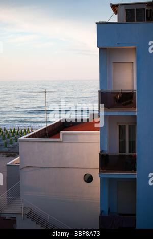 Modernes Wohngebäude mit Balkonen mit atemberaubendem Meerblick und schönem, ruhigem Meer in der Ferne. Stockfoto