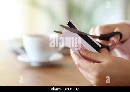 Nahaufnahme einer Frauenhand, die zu Hause Kreditkartenschnitte mit einer Schere zerstört Stockfoto