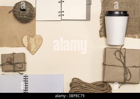 Produkte aus recyceltem Kraftpapier und Holz: Pakete, Notizbuch, Einweg-Kaffeetasse, Holzherz, Kabel. Begriff Umweltschutz, r Stockfoto