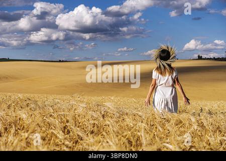 Essen, Frau in weißem Kleid steht auf dem Feld mit Weizen Stockfoto