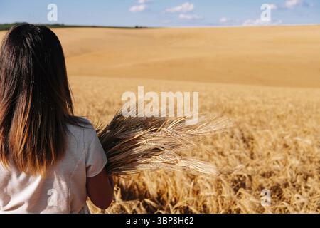 Essen, Frau in weißem Kleid steht auf dem Feld mit Weizen Stockfoto