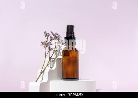 Pumpe Bernstein Glas Kosmetikflasche mit Creme oder Flüssigkeit für die Hautpflege auf weißem Beton Podium auf rosa Hintergrund. Natürliches Hautpflegekonzept Stockfoto