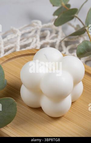 Bubble-Aromakerze mit dem Aroma von Gewürzen und Eukalyptus auf Holztablett. Herbstatmosphäre mit gemütlichem Lifestyle Stockfoto