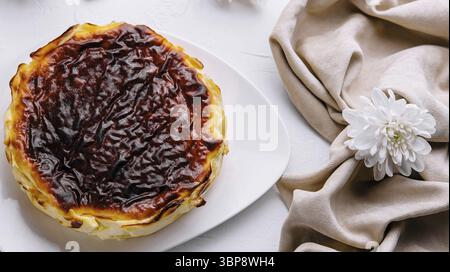 Essen, köstliches Pastell de nata mit karamellisierter Platte, serviert auf einem weißen Teller, umgeben von elegantem Tischdekor Stockfoto