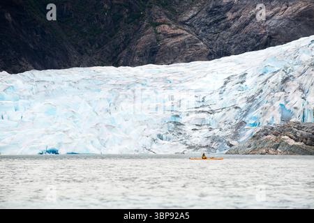 Ein Mann fährt mit dem Kajak auf dem Mendenhall Lake, wo der 21 km lange Mendenhall-Gletscher in Juneau, Alaska, endet. Stockfoto
