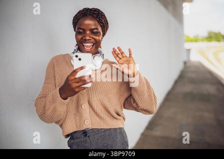 Porträt einer jungen schwarzen Frau, die Videoanrufe auf dem Smartphone führt. Stockfoto