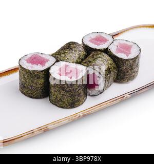 Das Essen, wunderschön arrangierte Sushi-Brötchen gefüllt mit frischem Thunfisch und Reis, in Nori gewickelt, sitzen auf einem eleganten weißen Teller und laden einen Geschmack japanischer Cuis ein Stockfoto