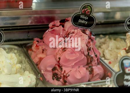 Verschiedene farbige Früchte köstliches Eis in Behältern auf Vitrine zum Verkauf im Sommer Stockfoto