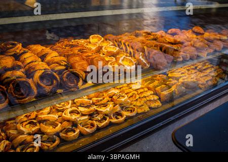 Dänisches Gebäck: Viele verschiedene süße Brötchen werden in der Bäckerei durch das Fenster von der Straße aus hergestellt Stockfoto