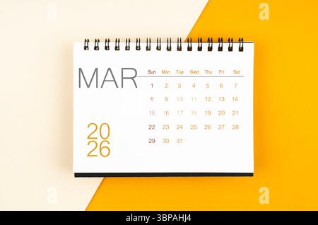 Schreibtischkalender für März 2026 auf gelbem Hintergrund. Stockfoto