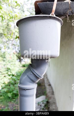 Eine Nahaufnahme eines grauen Rinnensystems: Eine praktische Lösung für eine effektive Wasserwirtschaft in Landschafts- und Wohnhäusern Stockfoto