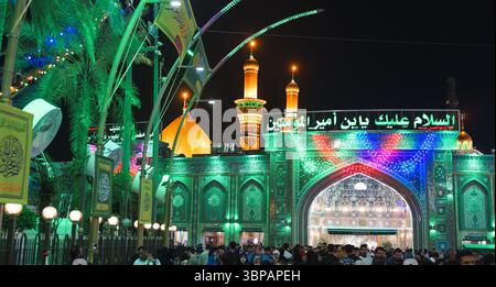 Tausende von Pilgern und Besuchern gehen zum Imam Hussein-Schrein in Karbala, der die lebhafte Atmosphäre der Nacht widerspiegelt. Stockfoto