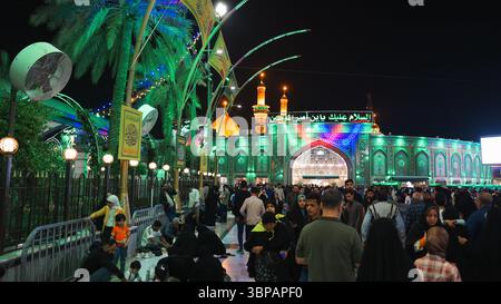 Menschen füllen den Innenhof des Imam Hussein-Schreins im IAQ Karbala, die an einem religiösen Ereignis voller Hingabe und Reflexion teilnehmen. Stockfoto