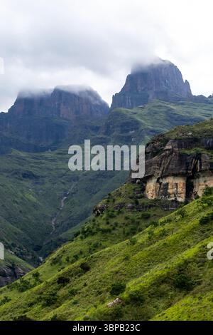 Dramatische Aussicht auf die Wächterspitzen, die sich in den sich sammelnden Wolken der Drakensberg Mountains in Südafrika erheben. Stockfoto