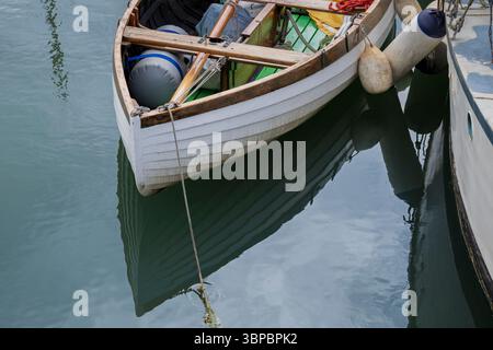 Hölzernes Boot mit Reflexen auf dem Wasser, Nahaufnahme. Stockfoto