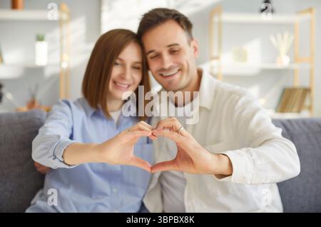 Verliebtes Paar, das Finger-Herz-Rahmen macht, liebevolles Porträt, glücklicher Mann und Frau in Liebe, Spaß haben Stockfoto