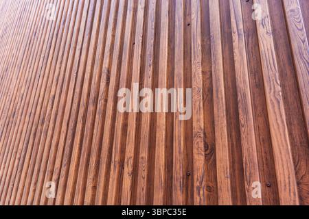 Architektur modernes braunes Gebäude mit vertikalem beschichtetem Holzmuster aus Metall-Stahl-Textur Hintergrund Stockfoto