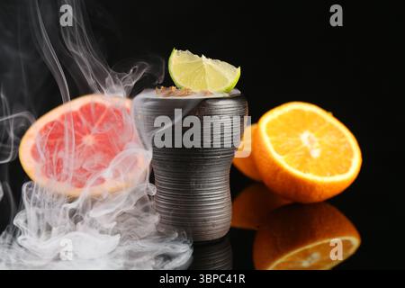 Shisha Schüssel mit Rauch und Früchten auf schwarzem Tisch, Nahaufnahme Stockfoto