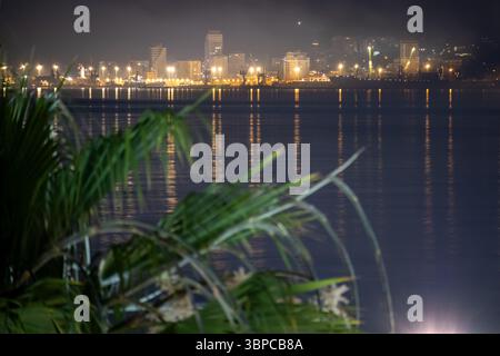 Atemberaubender Blick bei Nacht auf durres, albanien, mit der pulsierenden Stadtlandschaft und einem hell beleuchteten Hafen, der sich wunderbar auf der ruhigen Meeresoberfläche spiegelt. PA Stockfoto