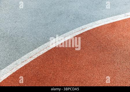 Gekrümmte Linien und Kontrastfarben erzeugen eine abstrakte Ansicht einer Rennbahn oder Sportfläche, die Bewegung, Energie oder Design suggeriert. Diese minimalistische Komposition Stockfoto