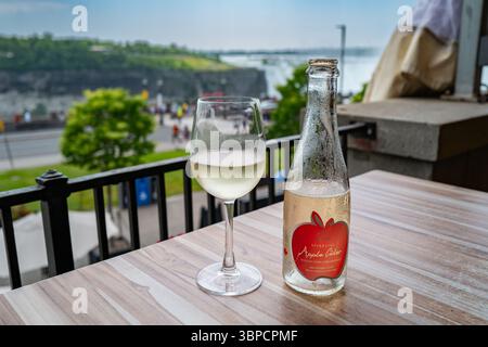 Eine Flasche Viene Apfelwein und Glas auf einem Tisch mit Blick auf die Niagarafälle von der kanadischen Seite. AG-Produkte sind in der US-Handelsproblematik verwickelt Stockfoto