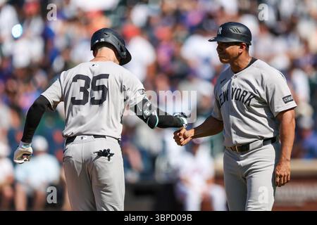 New York Yankees Cody Bellinger (35) wird von 3B-Trainer Luis Rojas (67) gratuliert, nachdem er am Freitag, 4. Juli 2025, im vierten Inning des Baseballspiels gegen die New York Mets im Citi Field in Corona, N.Y. einen Homerun getroffen hat. (Foto: Gordon Donovan) Stockfoto