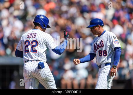 New York Mets Juan Soto (22) wird von 3B-Trainer Mike Sarbaugh (88) gratuliert, nachdem er am Freitag, den 4. Juli 2025, einen homer mit zwei Runs geschlagen hatte. (Foto: Gordon Donovan) Stockfoto