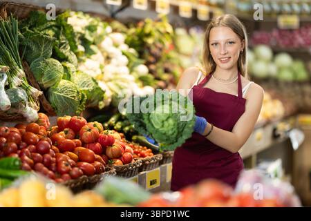 Weibliche Lebensmittelläden bieten Reifen Brokkoli-Kohl in der Lebensmittelabteilung des Supermarktes an Stockfoto