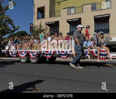 Orinda 4. Juli Parade: Kinder fahren auf einem Wohnwagen, während sie auf Heubügeln sitzen. Stockfoto