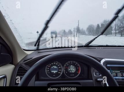 Blick des Fahrers durch die Windschutzscheibe an einem verschneiten Wintertag Stockfoto