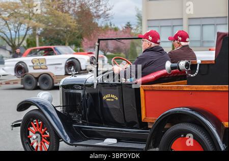 Rentner in einem Oldtimer. Zwei ältere Männer in einem Sportwagen. Ältere Freunde haben Spaß in einem Cabrio, das in einer Straße in Vancouver Kanada fährt. Tw Stockfoto