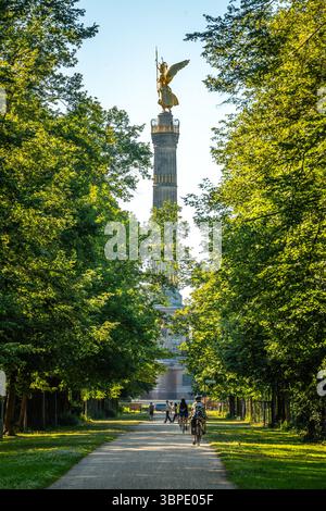Die Siegessäule Berlins erhebt sich bei einem goldenen Sommeruntergang über den Bäumen des Tiergartens, der sich am Abendhimmel abhebt. Stockfoto