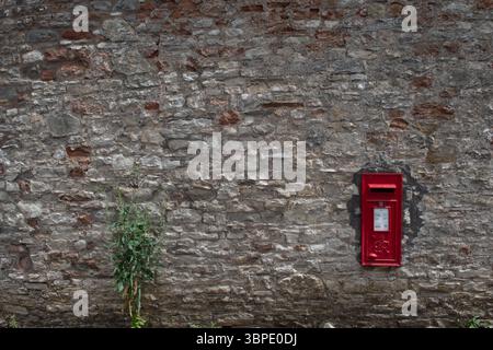 Roter Briefkasten in einer Wand, Stanton Drew, Somerset, England Stockfoto